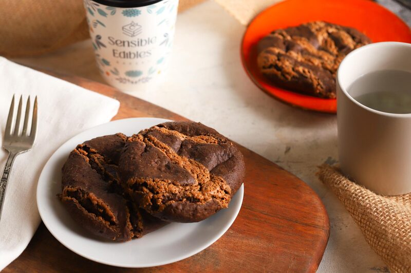 Chocolate chia cookies on a plate with a Sensible Edibles cup