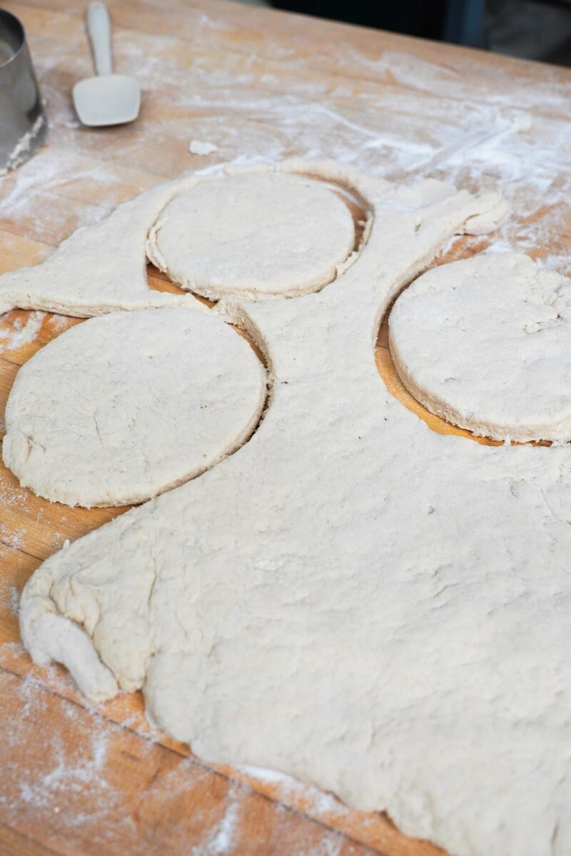 Gluten-free dough rolled out on a floured board with rounds cut using a circular cutter