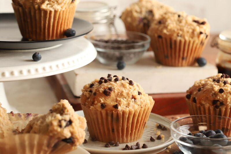 Golden chocolate chip muffins with high domed tops on a tiered stand