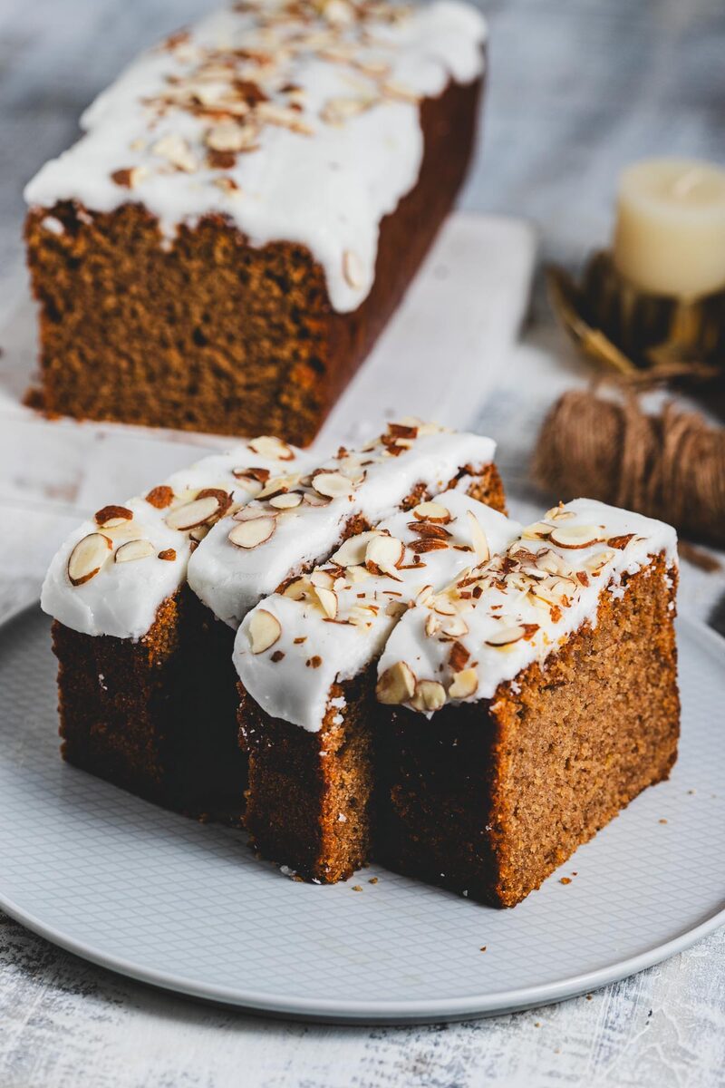 A sliced glazed spice loaf cake showing an even, well-risen crumb