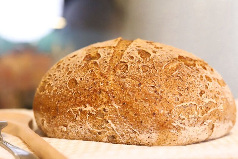 Round artisan loaf of gluten-free bread on a wooden board