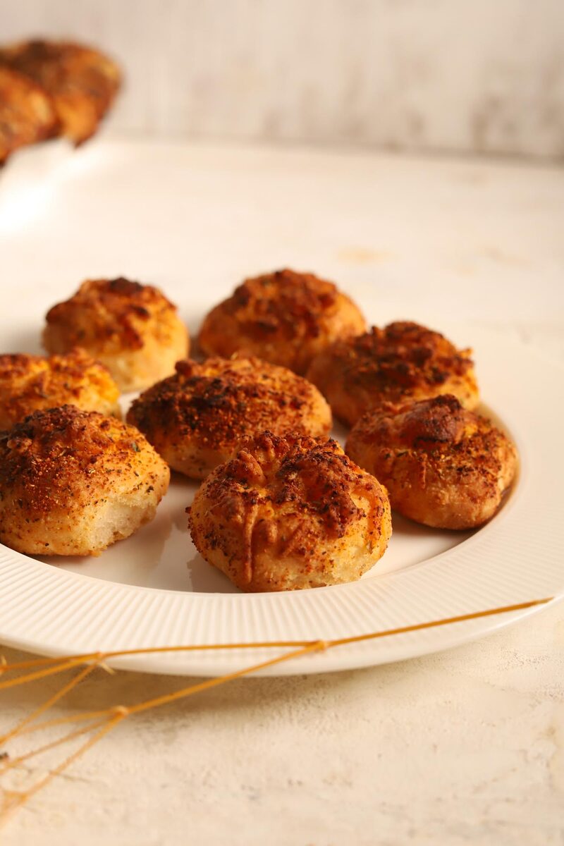 Golden gluten-free cheesy rolls on a white plate