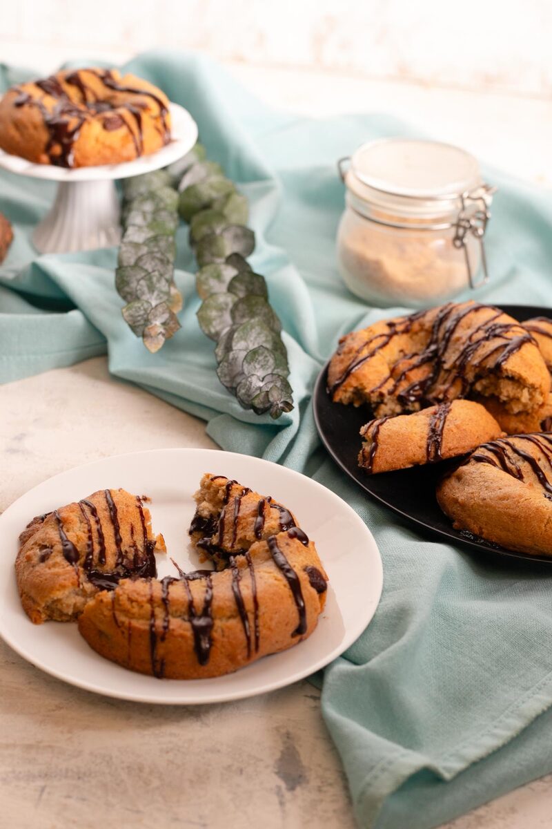 A lava cookie torn in half on a white plate showing the dark molten ganache center