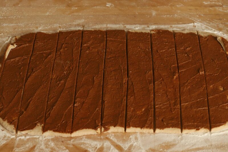 Slicing the filled dough sheet into strips before rolling each one up