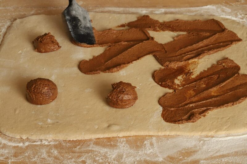 Spreading whipped cinnamon filling across the rolled-out dough