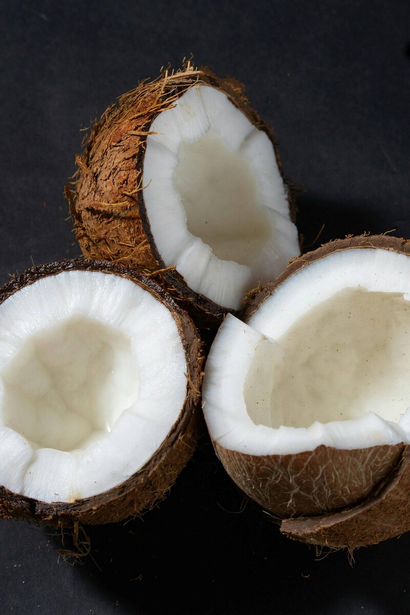 Three coconut halves on a dark background