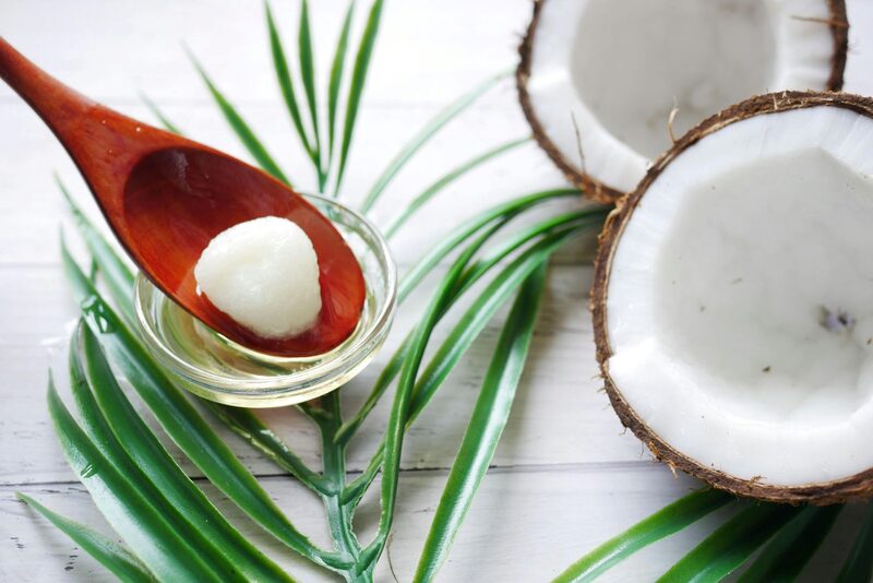 Coconut oil in a bowl beside fresh coconut halves