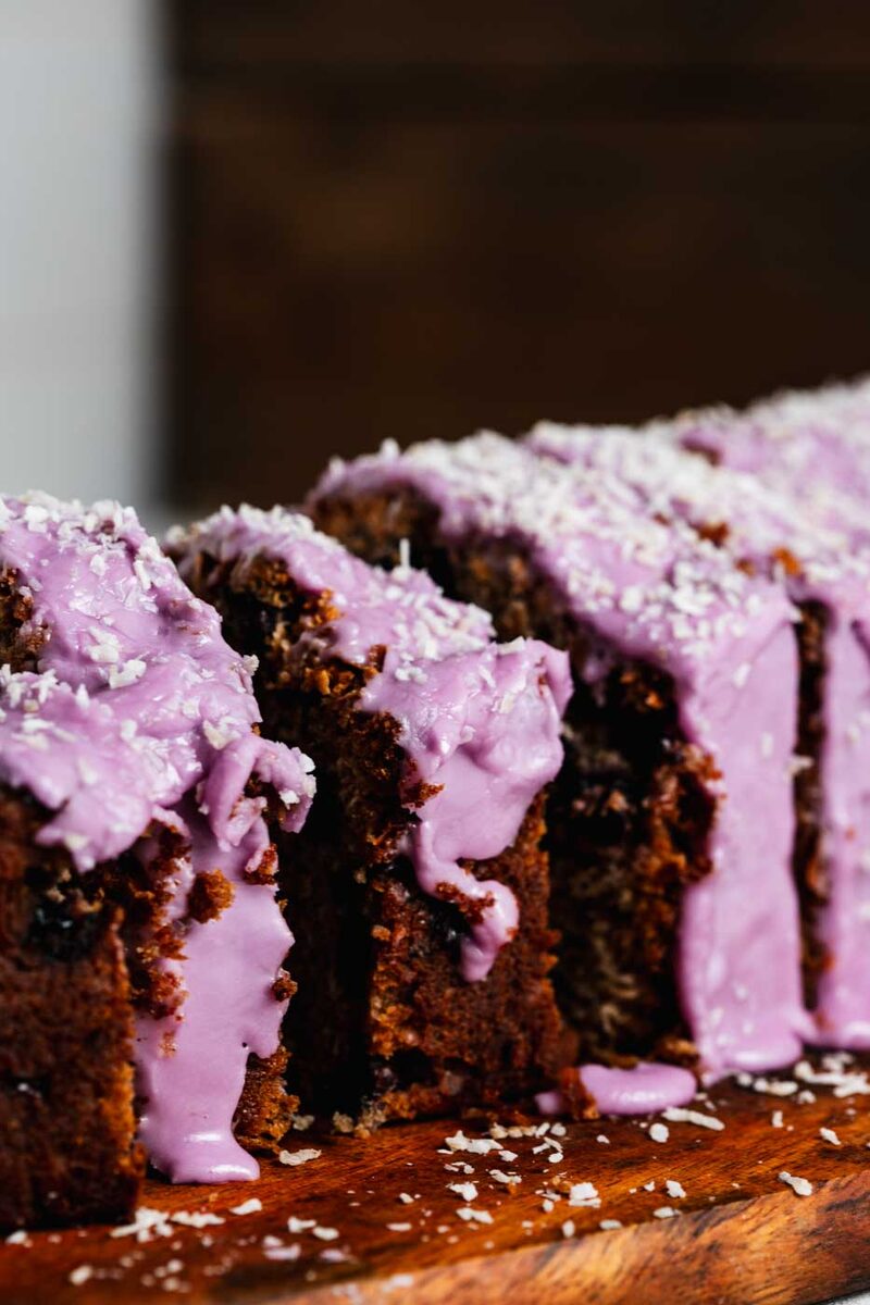 Loaf cake with vibrant purple glaze and shredded coconut