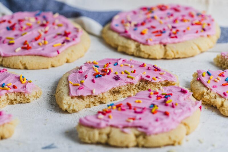 Pink-frosted sugar cookies topped with rainbow sprinkles