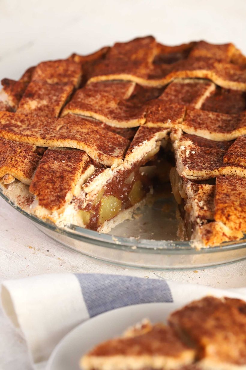 A vegan gluten-free lattice apple pie with a glossy, golden-brown crust from a 1:1 maple and olive oil egg wash
