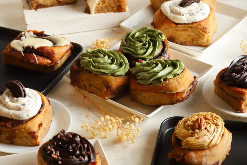An assortment of gluten-free buns and rolls with different frostings and toppings