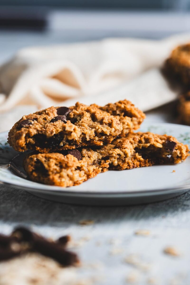 Close-up of a gluten-free oatmeal chocolate chip cookie split in half, showing a soft, even crumb