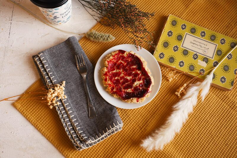 A gluten-free fruit tart plated on a styled table with a napkin and fork