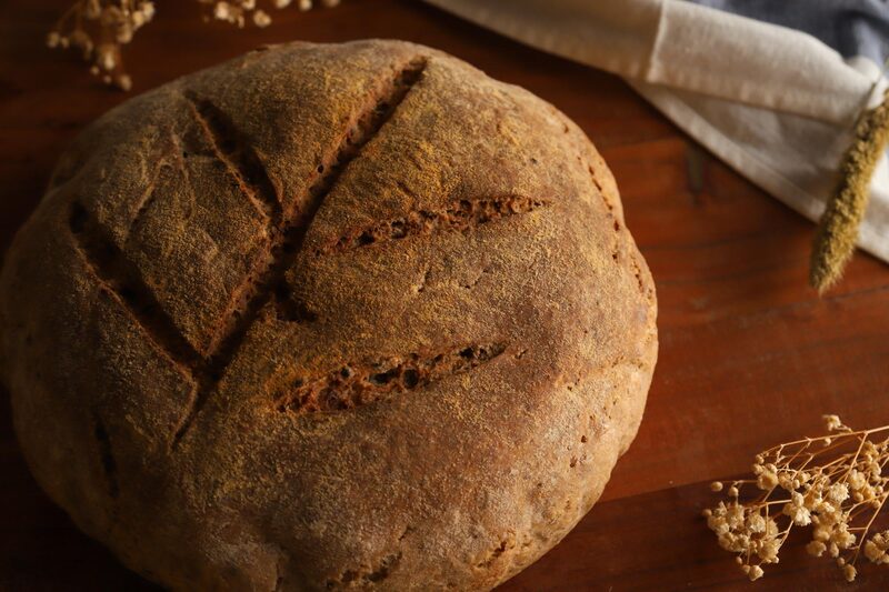 Close-up of a gluten-free sourdough loaf with decorative scoring across the top