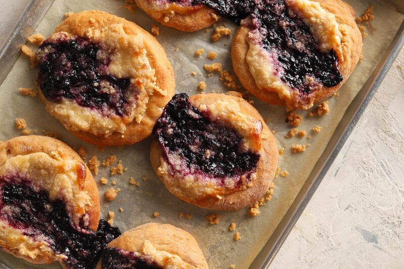 Gluten-free blueberry cookies on a baking sheet, broken open to show jammy centers
