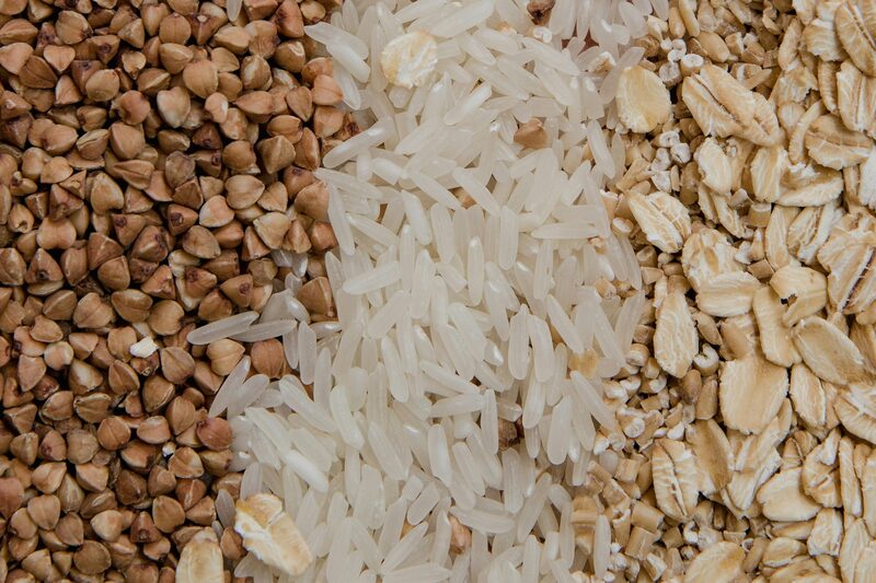 Buckwheat, white rice, and rolled oats arranged side by side