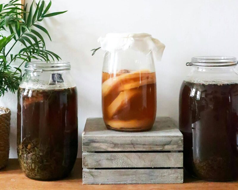 Glass jar of kombucha with a scoby floating on top