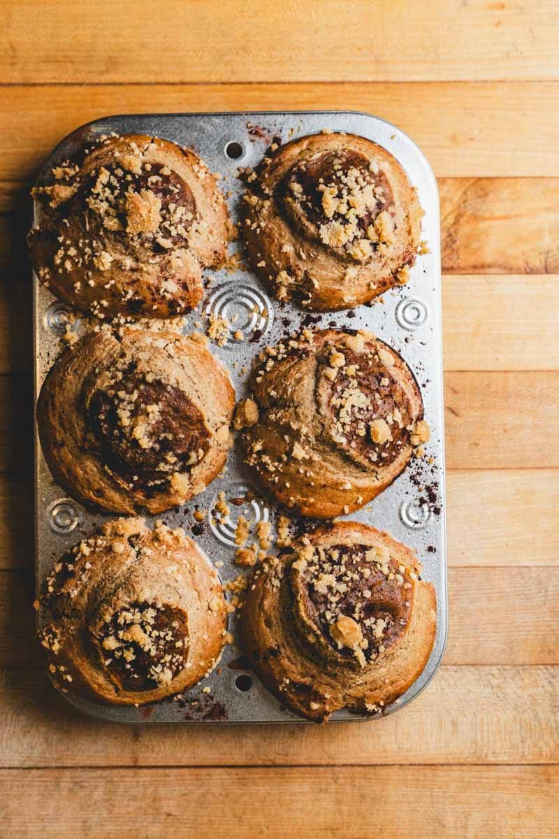 A muffin tin of pumpkin pie muffins with crumb topping