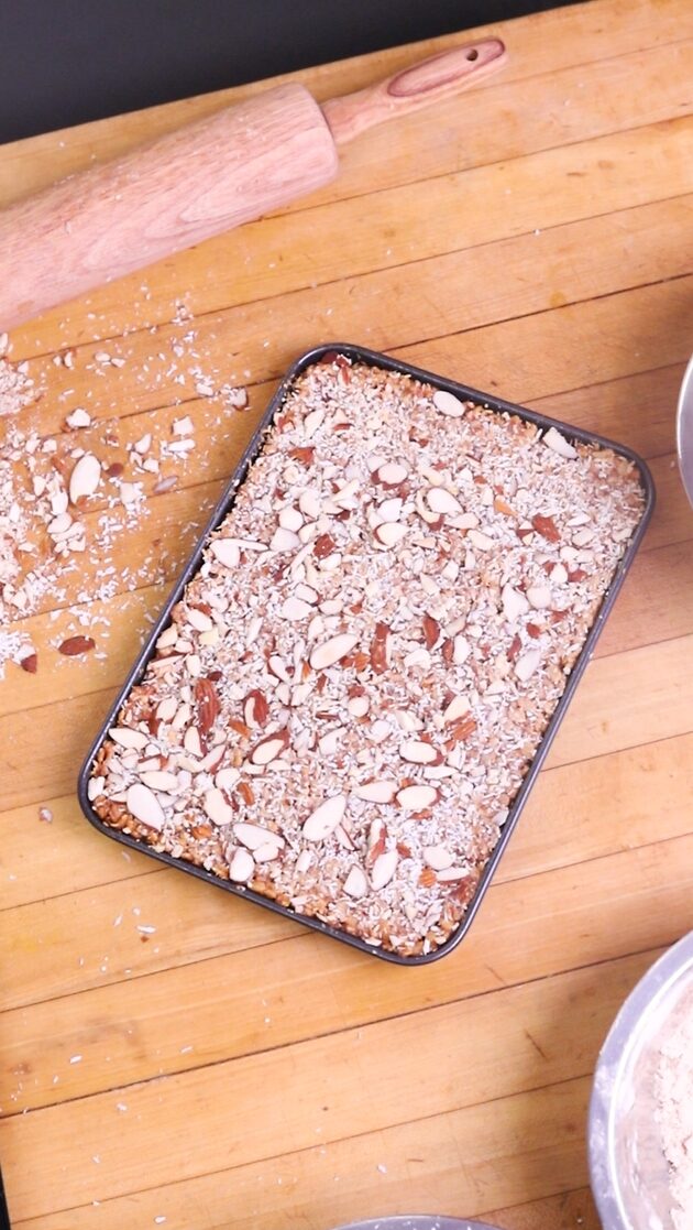 Tray of finished rice krispie treats topped with almonds and coconut