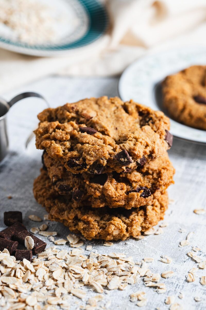 Stack of oatmeal chocolate chunk cookies with rolled oats scattered around
