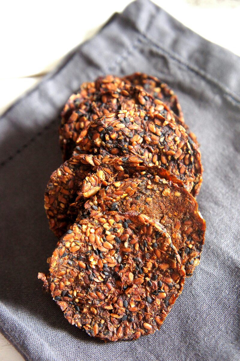 Round seed crackers fanned out on a grey linen napkin