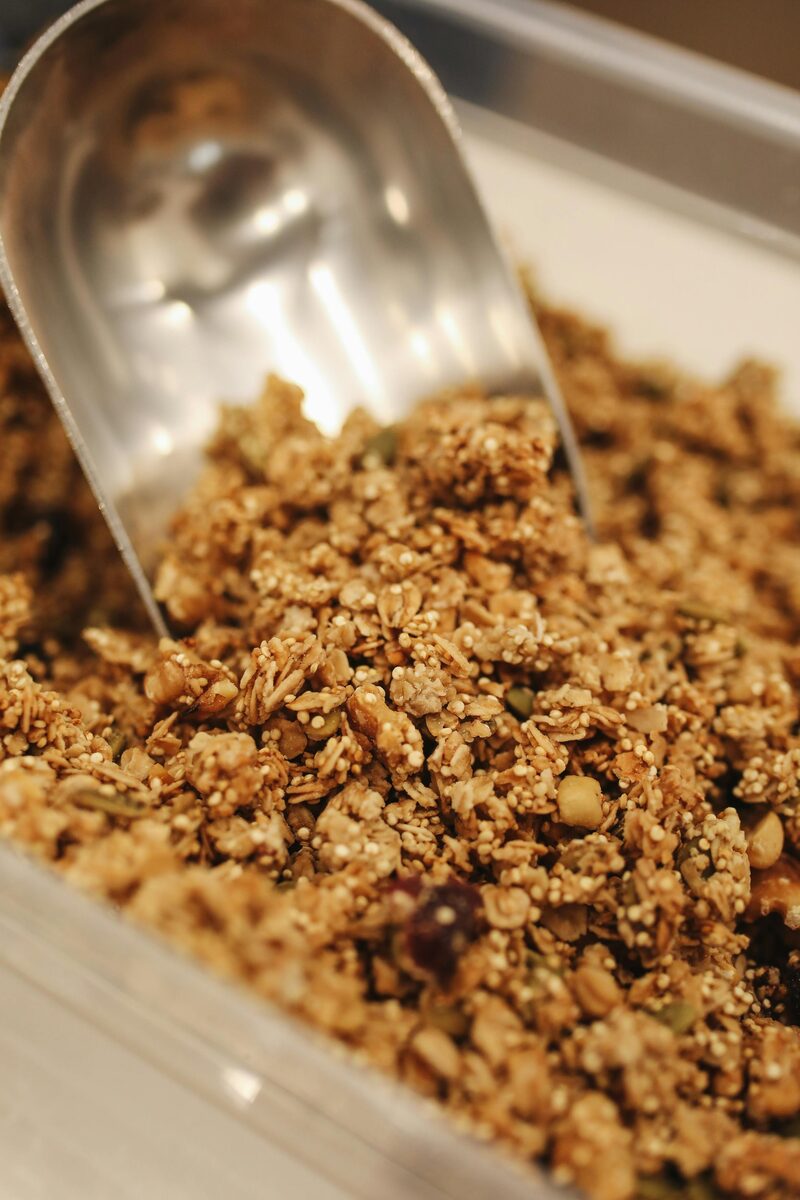 Sprouted granola being scooped from a metal baking tray
