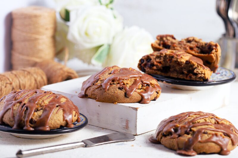 Glazed gluten-free date scones on small plates, one split open to show the moist crumb