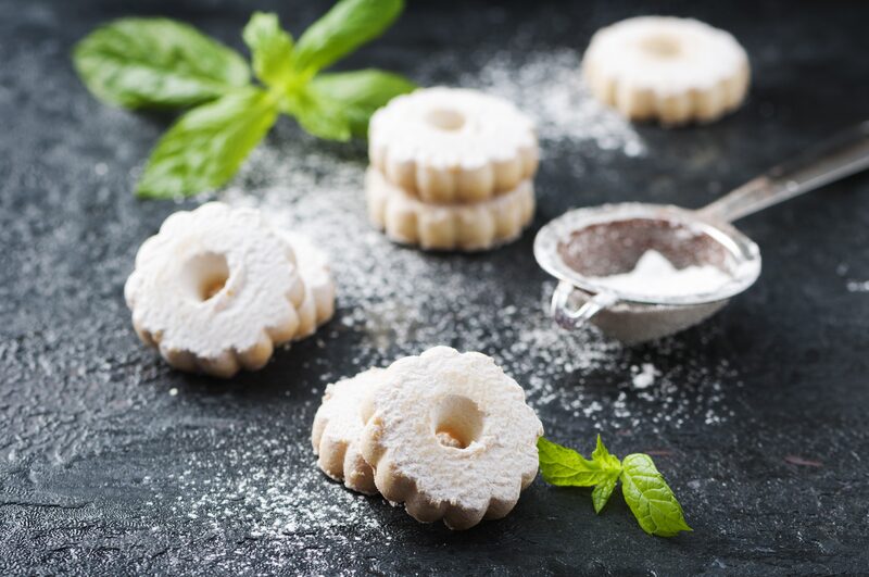 Delicate cookies dusted with powdered sugar and garnished with mint leaves