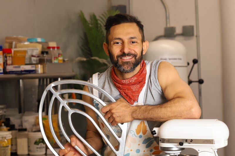 Wassem Moarsi holding a fresh-baked brownie at Sensible Edible Bakery