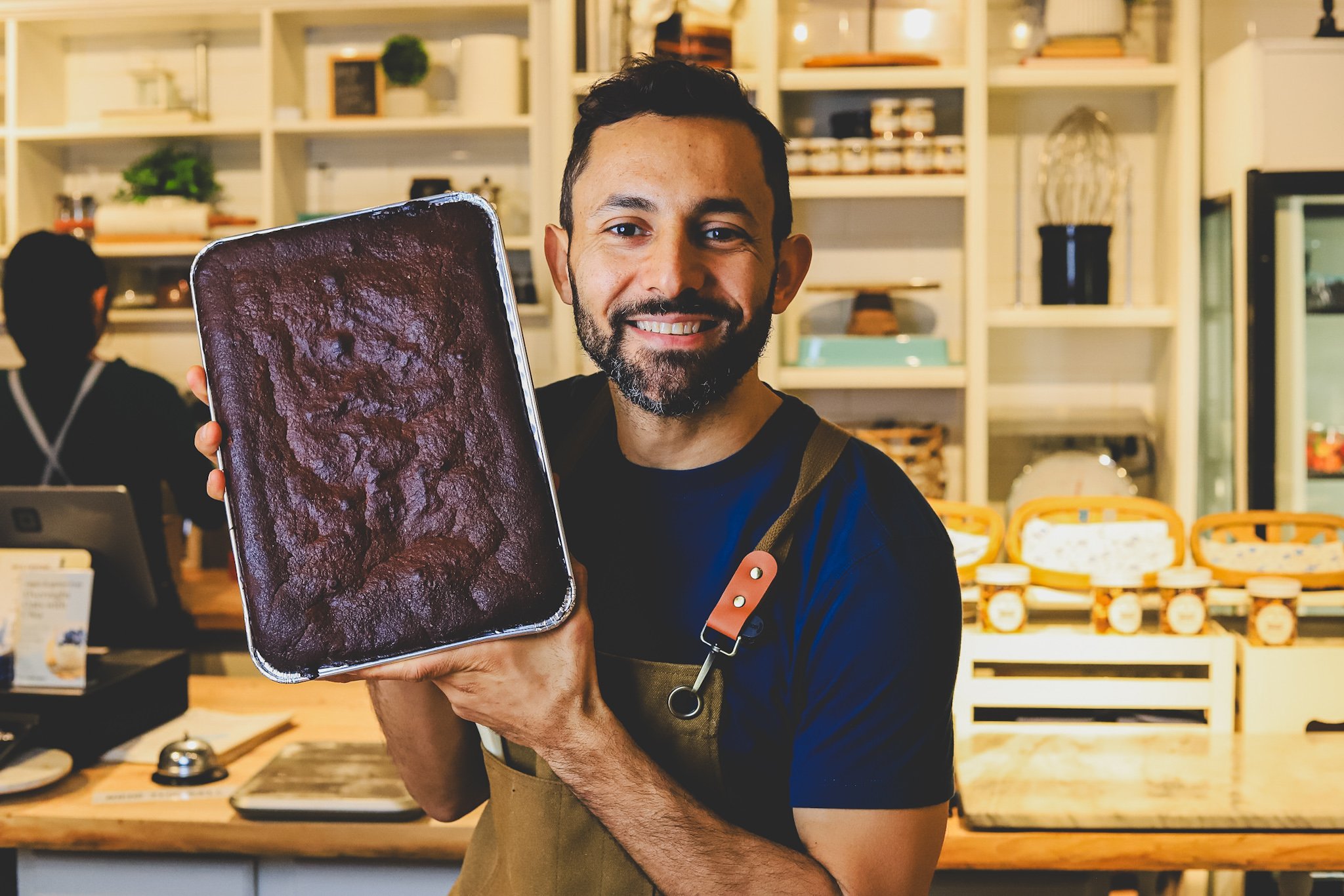 Wassem Moarsi holding a fresh-baked brownie at Sensible Edible Bakery
